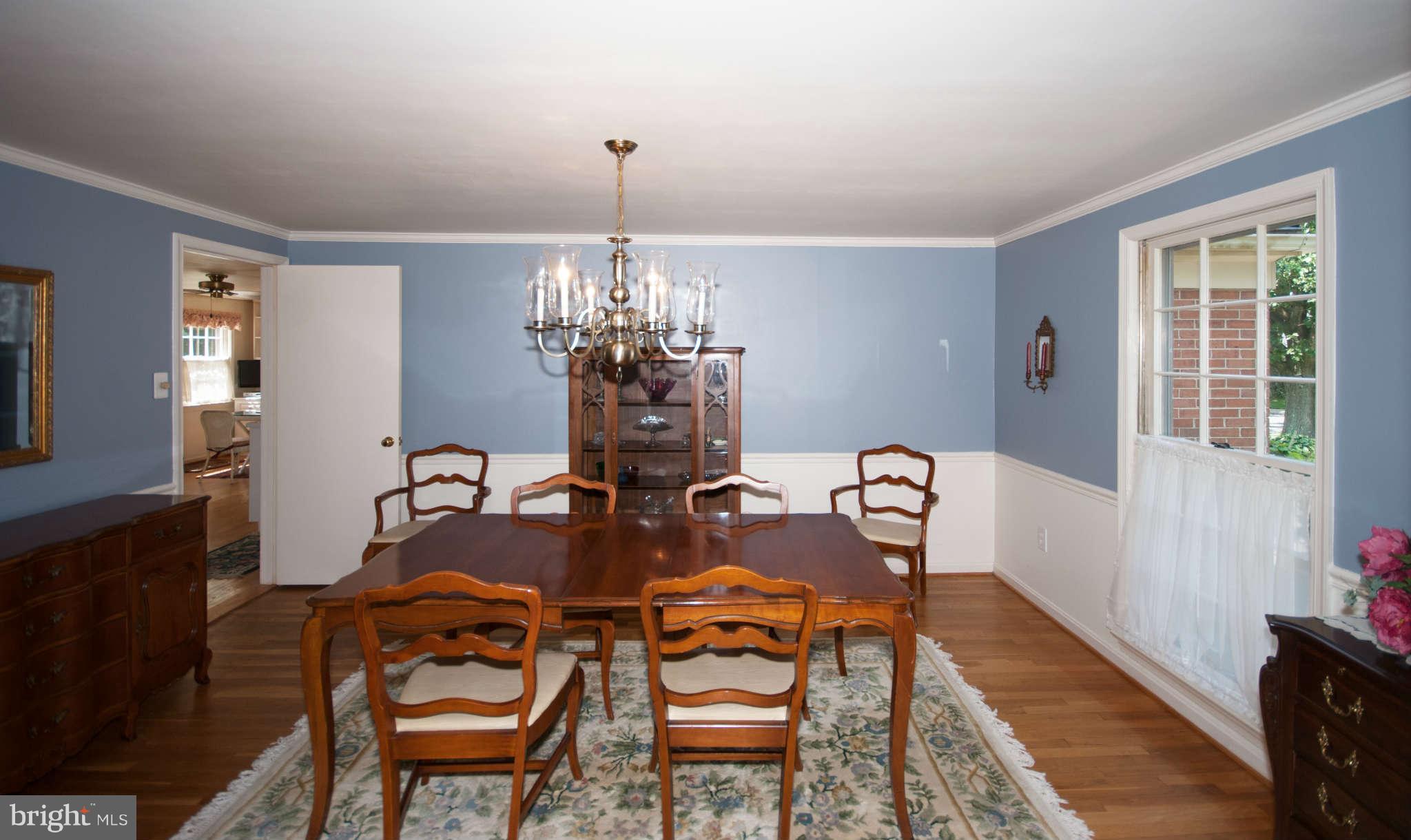 12433 Over Ridge Road Potomac, MD 20854 - Photo 11 of 30 a view of a dining room with furniture a chandelier and wooden floor