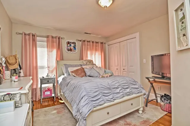 a bedroom with a bed dresser and a flat tv screen
