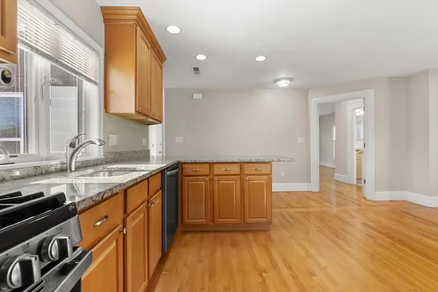a kitchen with granite countertop a sink stove and cabinets
