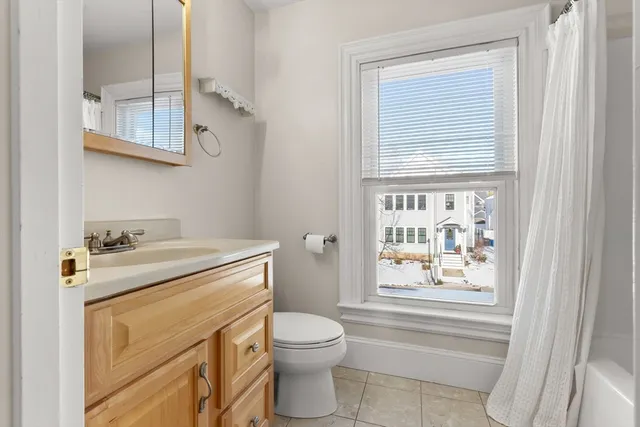 a bathroom with a granite countertop toilet sink and mirror