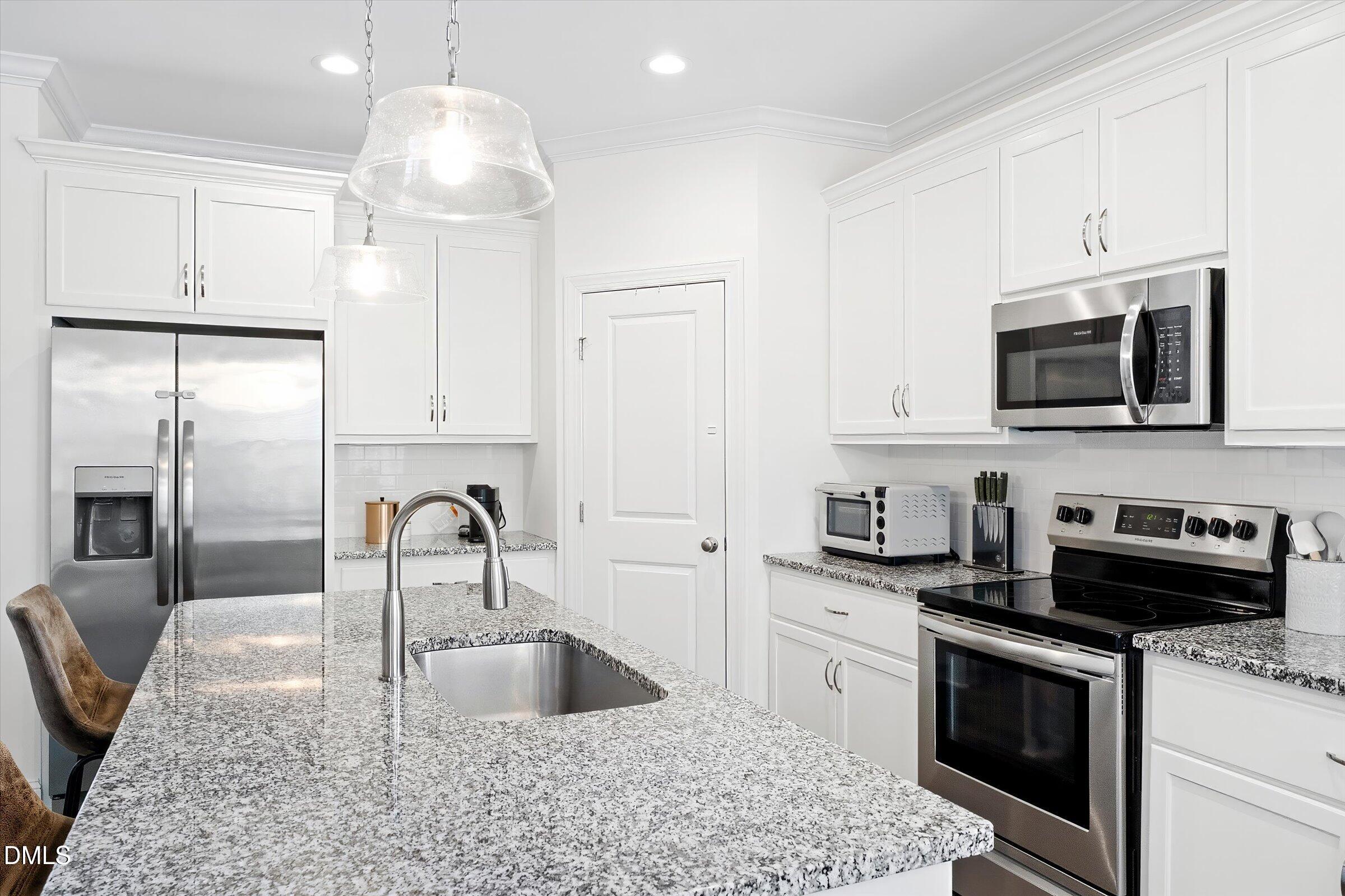 116 Nairn Street Fayetteville, NC 28311 - Photo 14 of 56 a kitchen with kitchen island granite countertop a sink stainless steel appliances and white cabinets