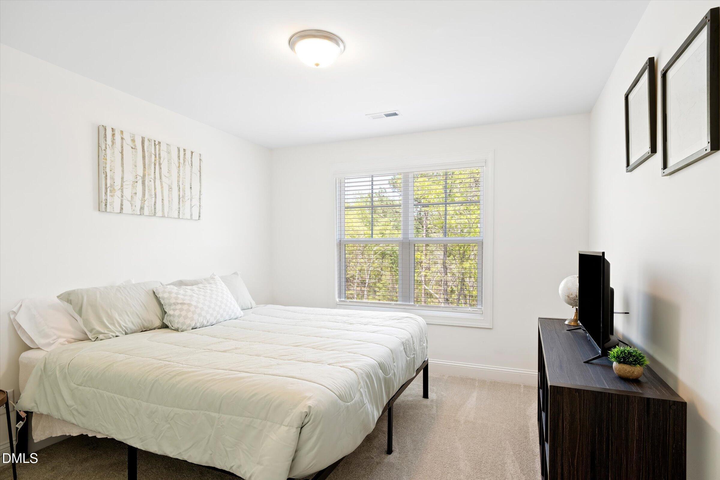 116 Nairn Street Fayetteville, NC 28311 - Photo 35 of 56 a bedroom with a bed and a flat tv screen on a dresser