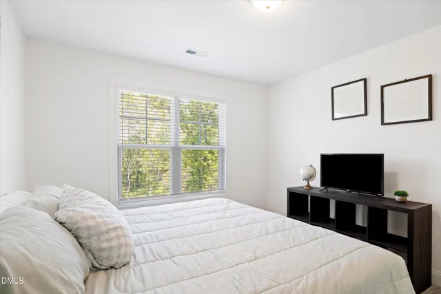 a bedroom with a bed and a window