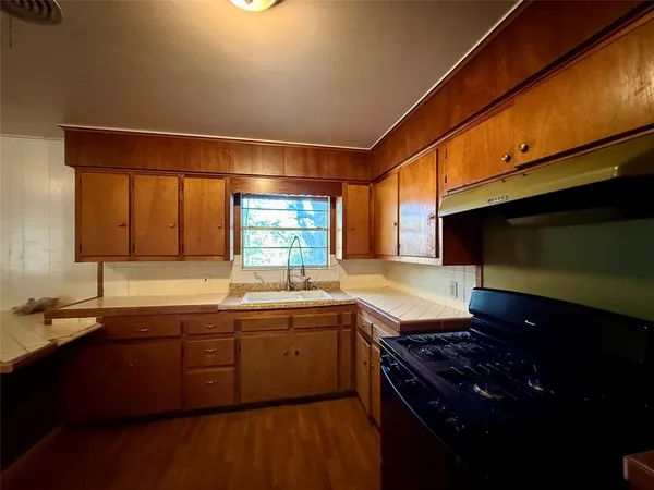 a kitchen with a sink stove and cabinets