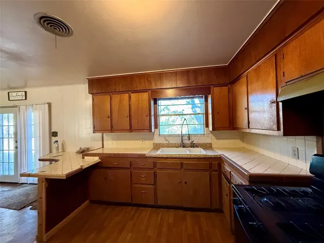 a kitchen with a sink stove and cabinets