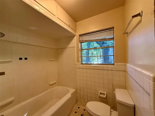 a bathroom with a granite countertop bathtub sink and toilet
