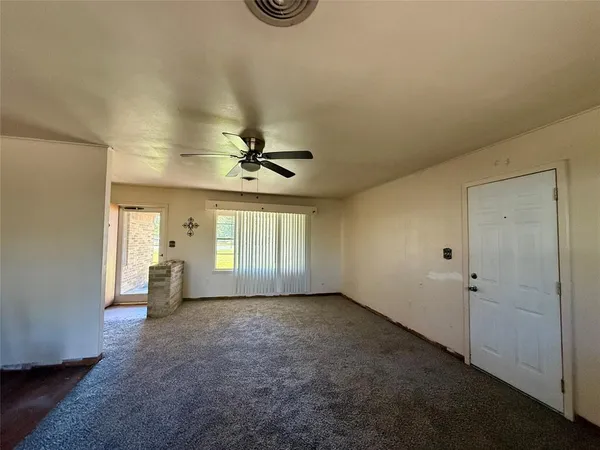 a view of a livingroom with a ceiling fan and window