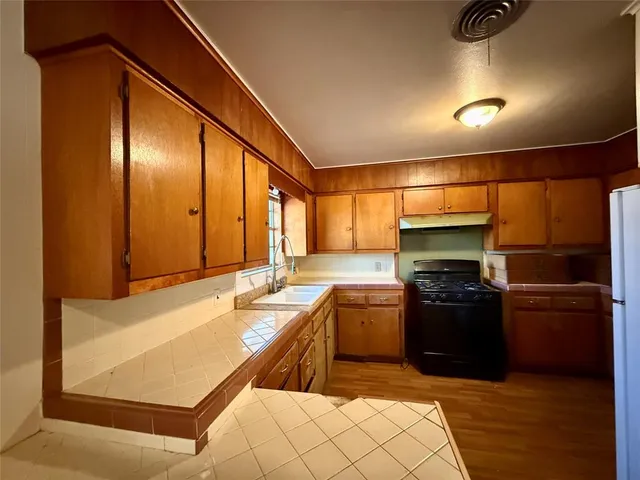 a kitchen with stainless steel appliances granite countertop a refrigerator and a stove