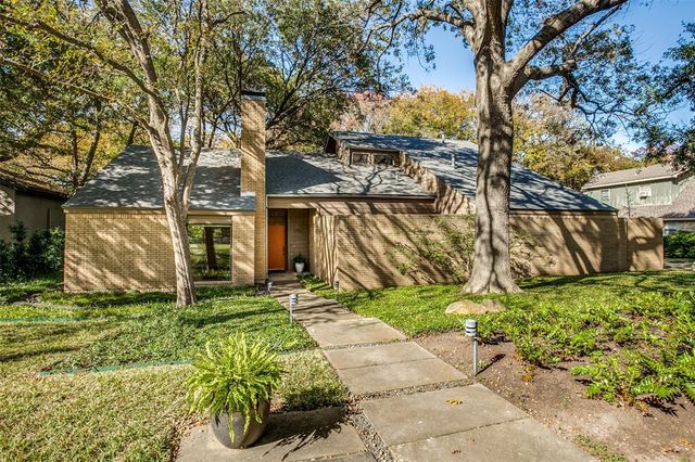 a yellow house with trees in front of it