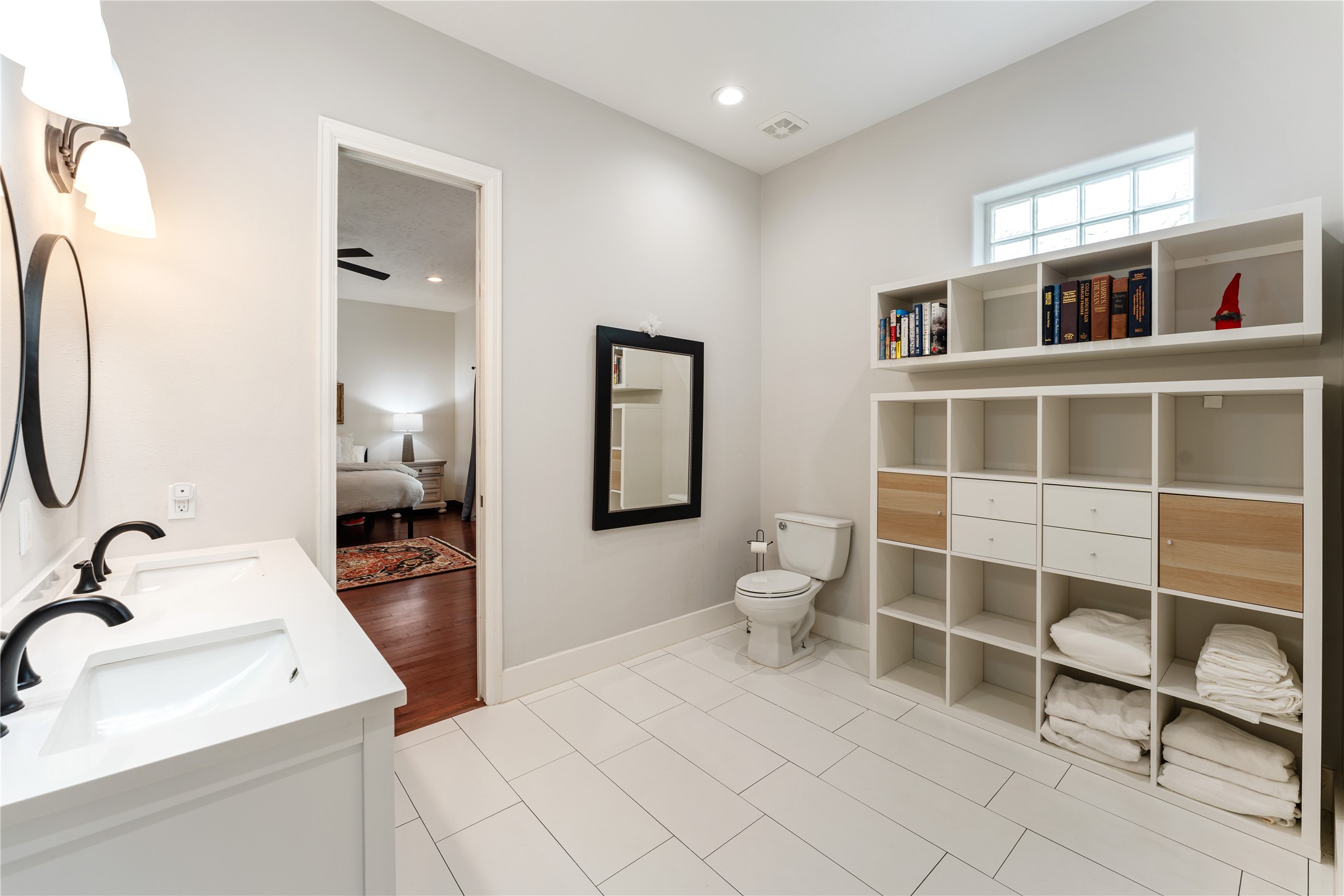 415 West 8th Street Houston, TX 77007 - Photo 13 of 39 Bright, spacious, and beautifully appointed, this luxurious bathroom offers an ideal blend of sophistication and practicality. Custom built-in storage provides exceptional organization while preserving the room's open, airy feel. The seamless connection to the primary suite creates a true spa-inspired owner's retreat.