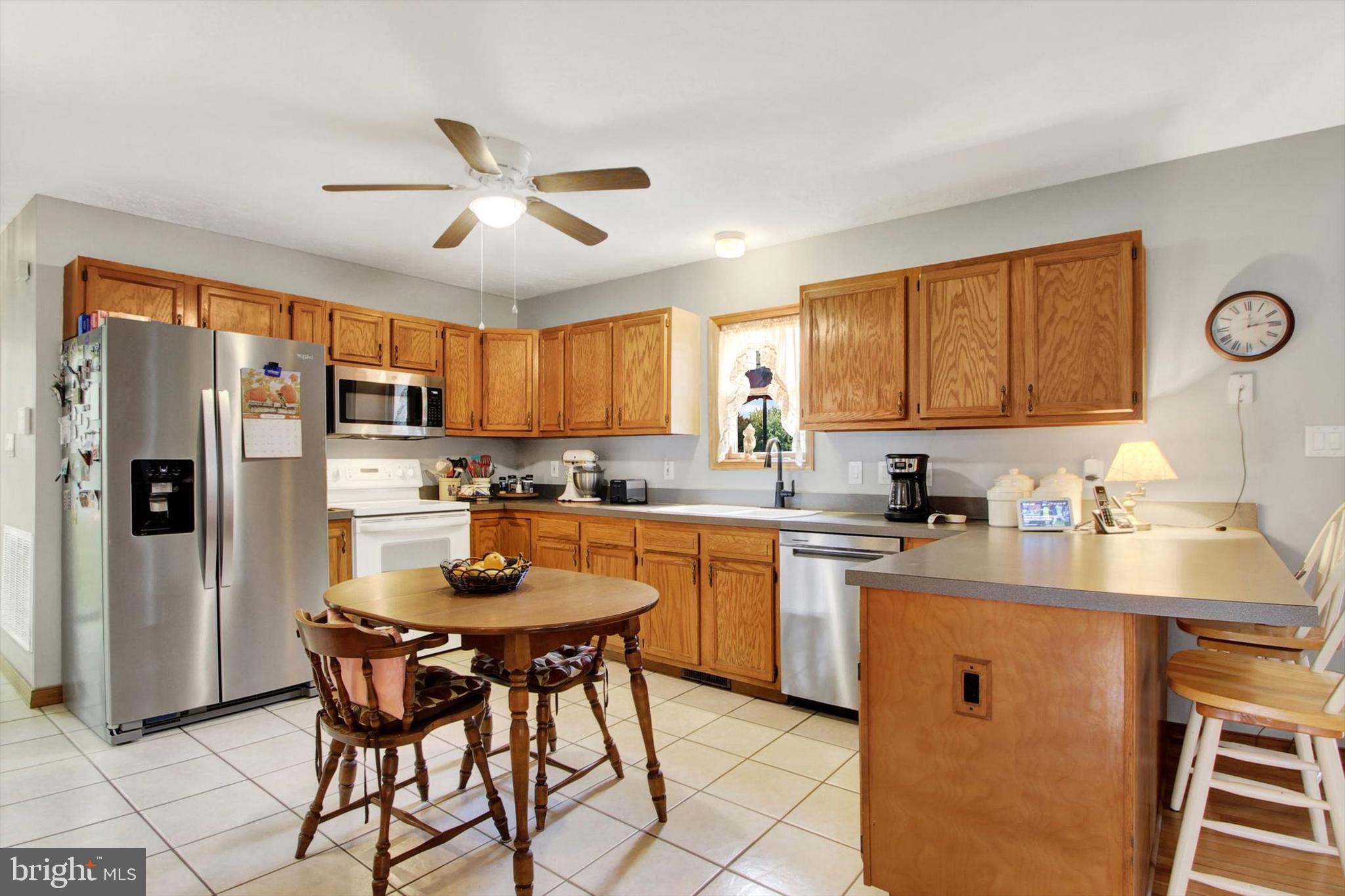 3744 Blue Hill Road Hanover, PA 17331 - Photo 11 of 32 a kitchen with stainless steel appliances granite countertop a refrigerator a sink dishwasher a dining table and chairs with wooden floor
