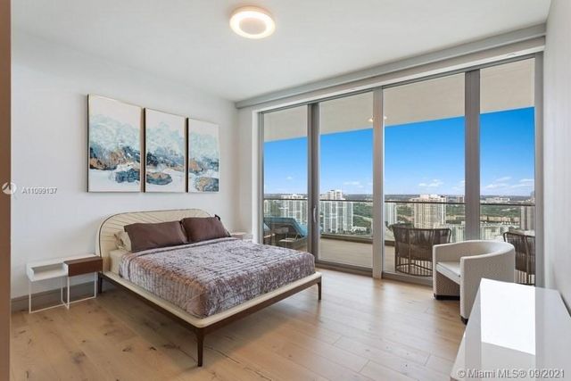 a bedroom with a large bed and a chandelier