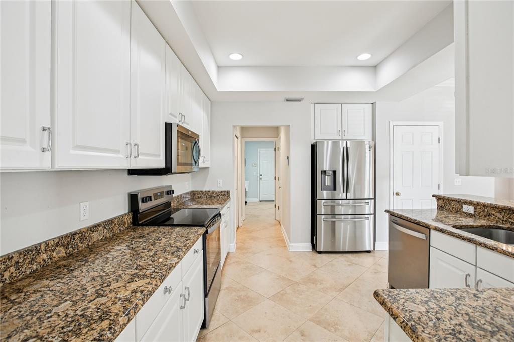 270 Cleveland Avenue Southwest Largo, FL 33770 - Photo 28 of 35 a kitchen with stainless steel appliances granite countertop a refrigerator stove and cabinets