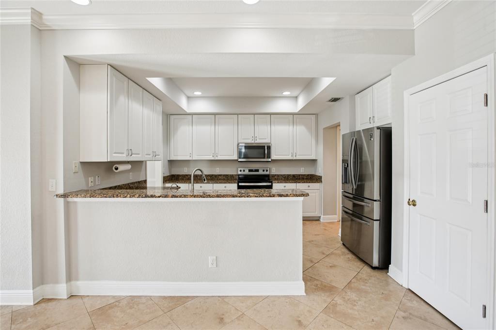 270 Cleveland Avenue Southwest Largo, FL 33770 - Photo 30 of 35 a kitchen with stainless steel appliances granite countertop a refrigerator a stove a sink and a microwave
