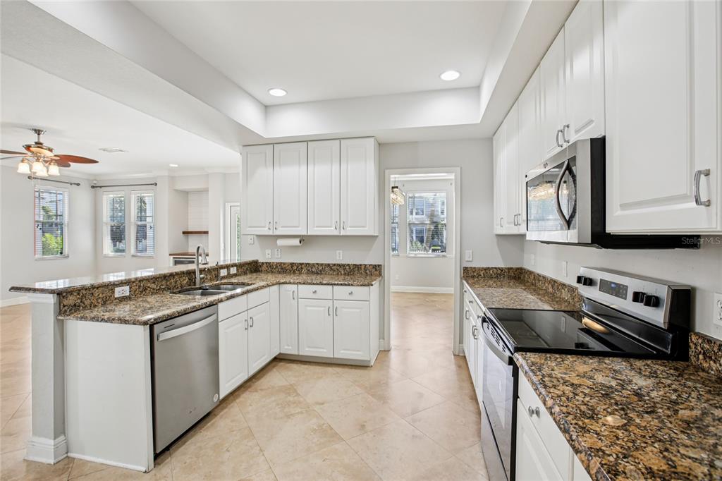 270 Cleveland Avenue Southwest Largo, FL 33770 - Photo 33 of 35 a kitchen with stainless steel appliances granite countertop a stove top oven a sink a refrigerator and white cabinets