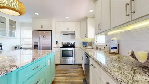 a kitchen with stainless steel appliances granite countertop a sink a stove and a refrigerator