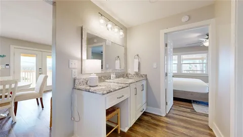 a en suite bathroom with a granite countertop double vanity and a mirror