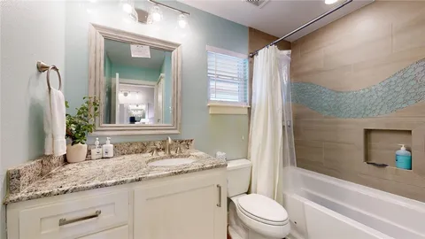 a bathroom with a granite countertop sink toilet mirror and shower