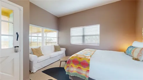 a bedroom with a bed and a couch next to a window