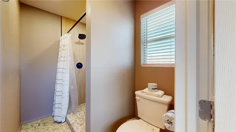 a bathroom with a toilet and a shower