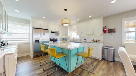 a kitchen with granite countertop lots of counter top space refrigerator dining table and windows