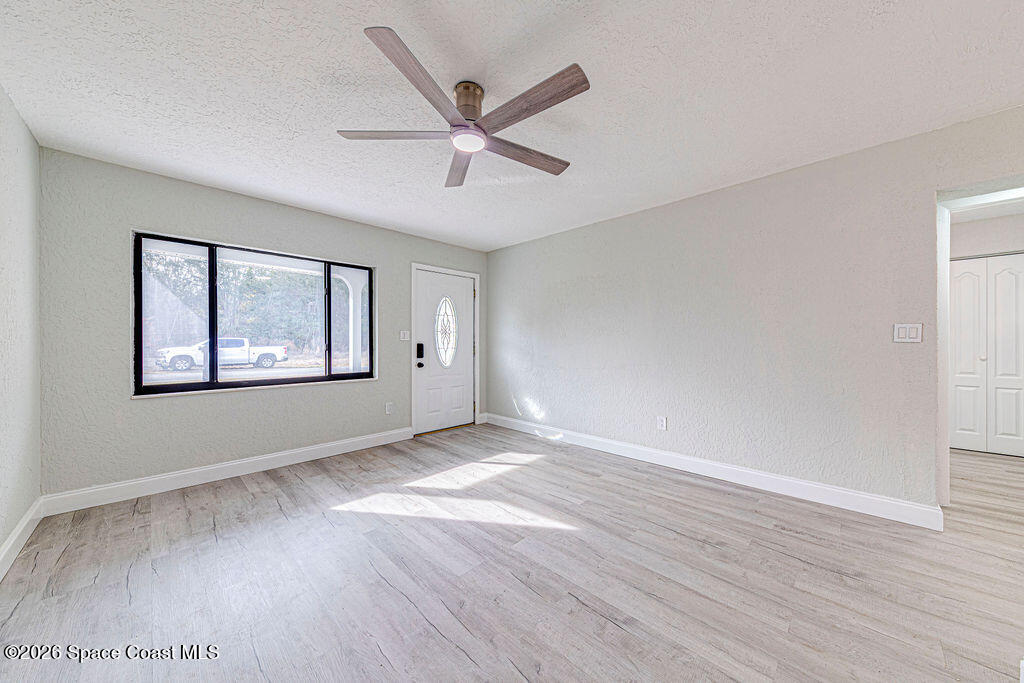 2773 Hickory Circle Mims, FL 32754 - Photo 11 of 45 a view of an empty room with window and wooden floor