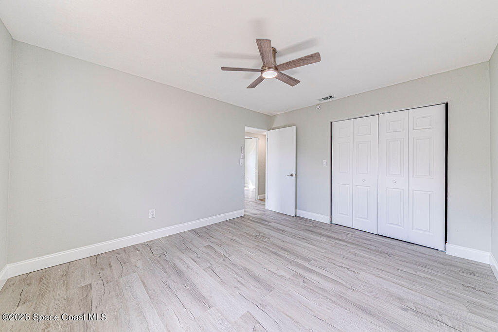 2773 Hickory Circle Mims, FL 32754 - Photo 23 of 45 an empty room with wooden floor fan and windows