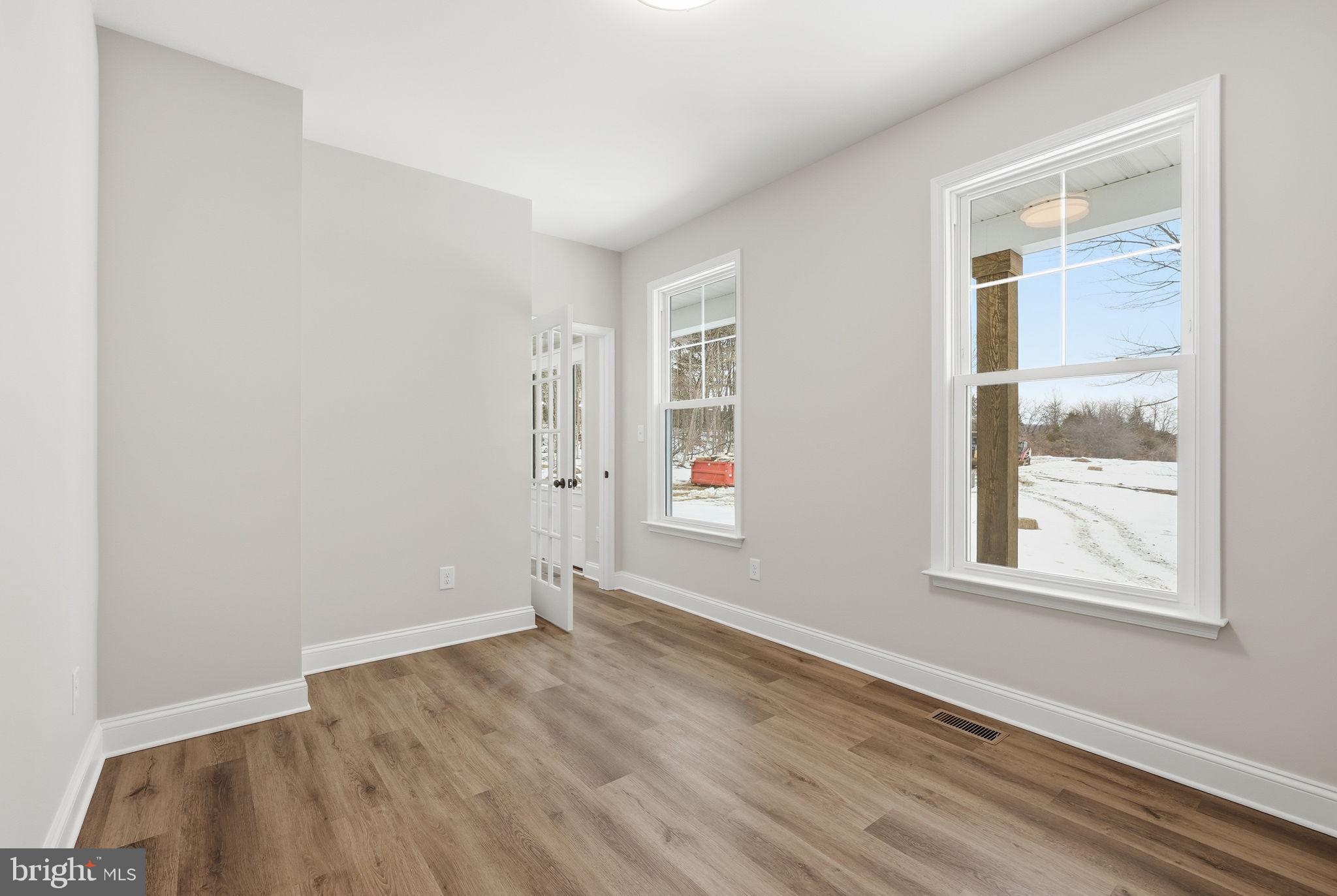 9586 South Pines Road Warrenton, VA 20186 - Photo 11 of 53 an empty room with wooden floor and windows