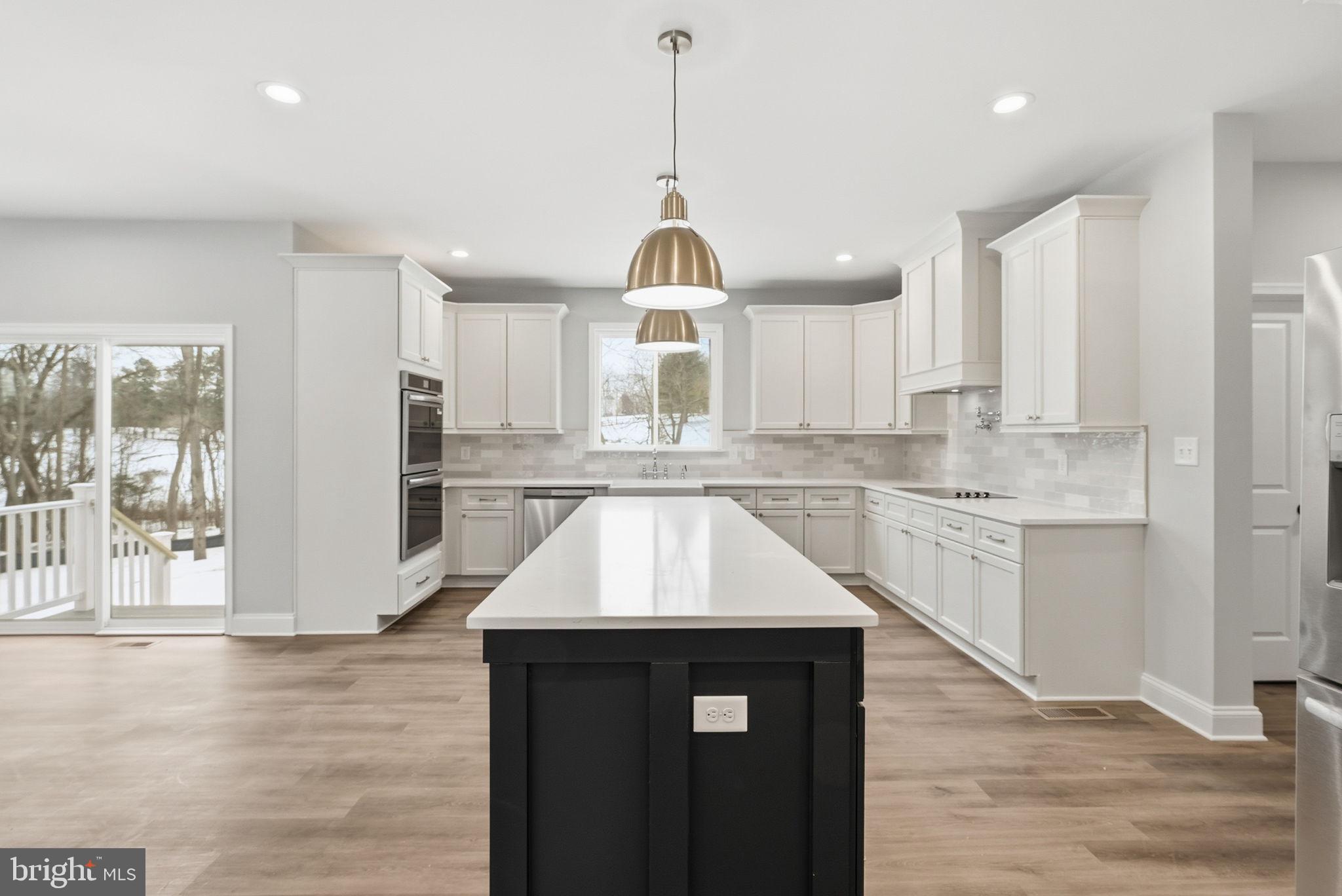 9586 South Pines Road Warrenton, VA 20186 - Photo 21 of 53 a kitchen with kitchen island granite countertop a stove a sink and a wooden floors