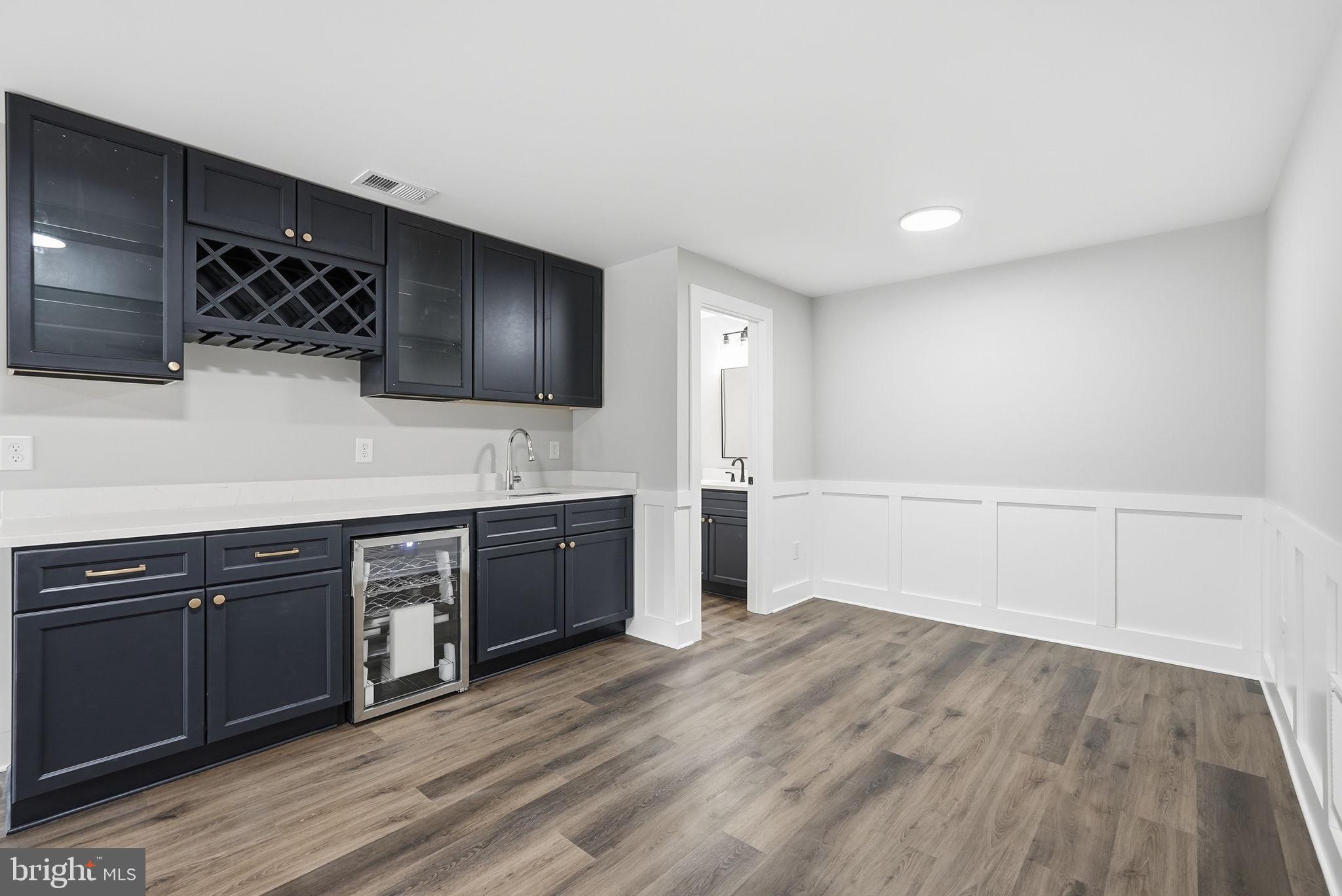 9586 South Pines Road Warrenton, VA 20186 - Photo 44 of 53 a large white kitchen with a sink and dishwasher a stove with wooden floor