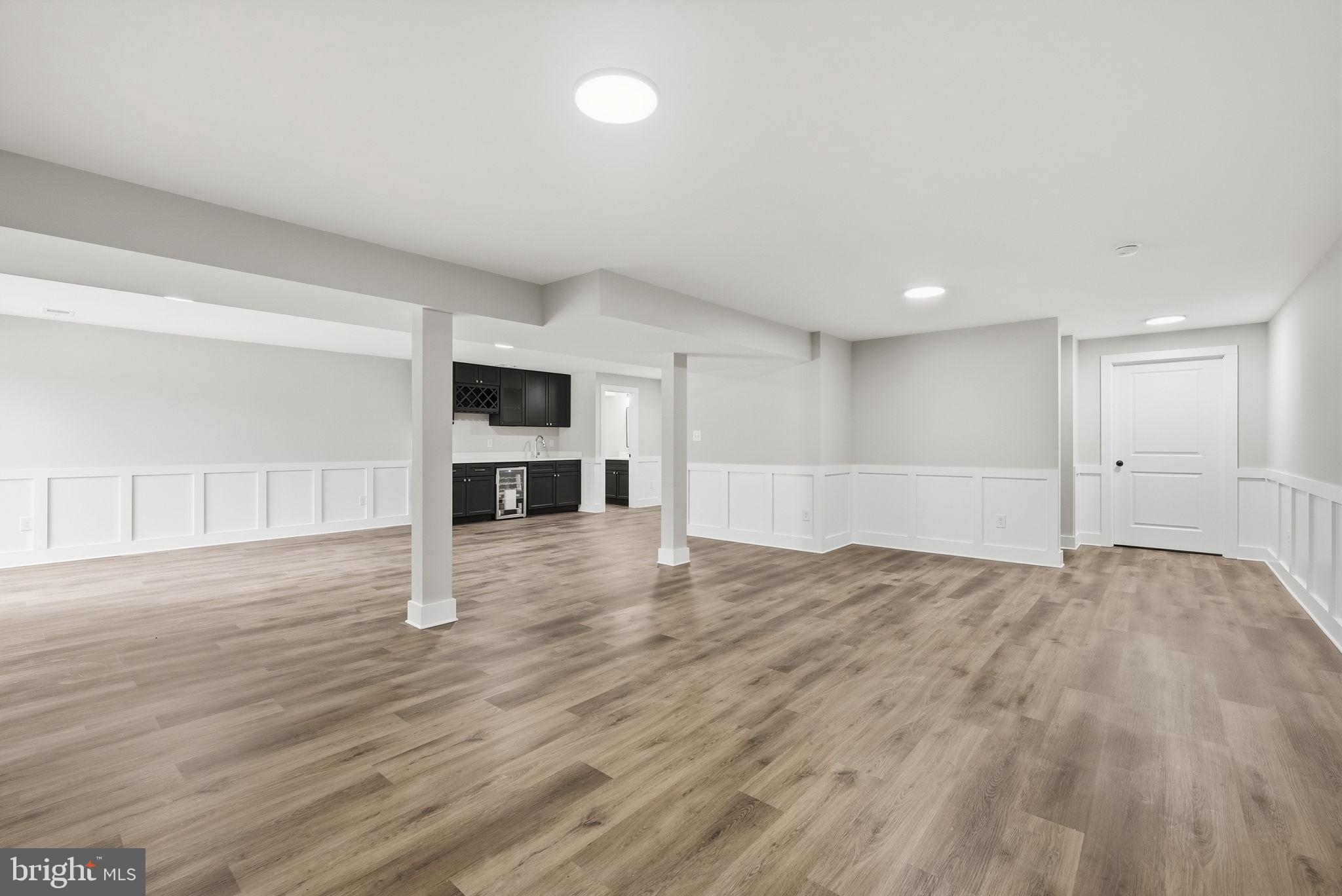 9586 South Pines Road Warrenton, VA 20186 - Photo 46 of 53 a view of empty room with wooden floor and kitchen
