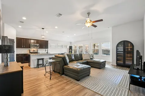 a living room with furniture and a wooden floor
