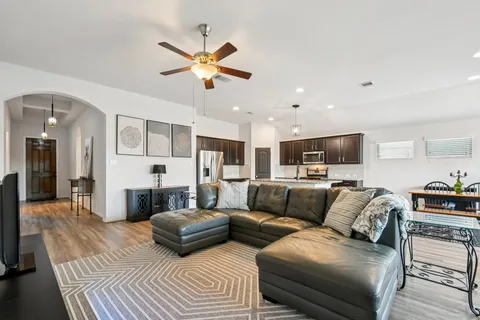 a living room with furniture and a view of kitchen