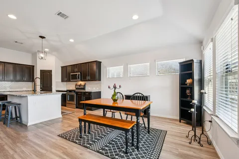 a living room with furniture a flat screen tv and kitchen view