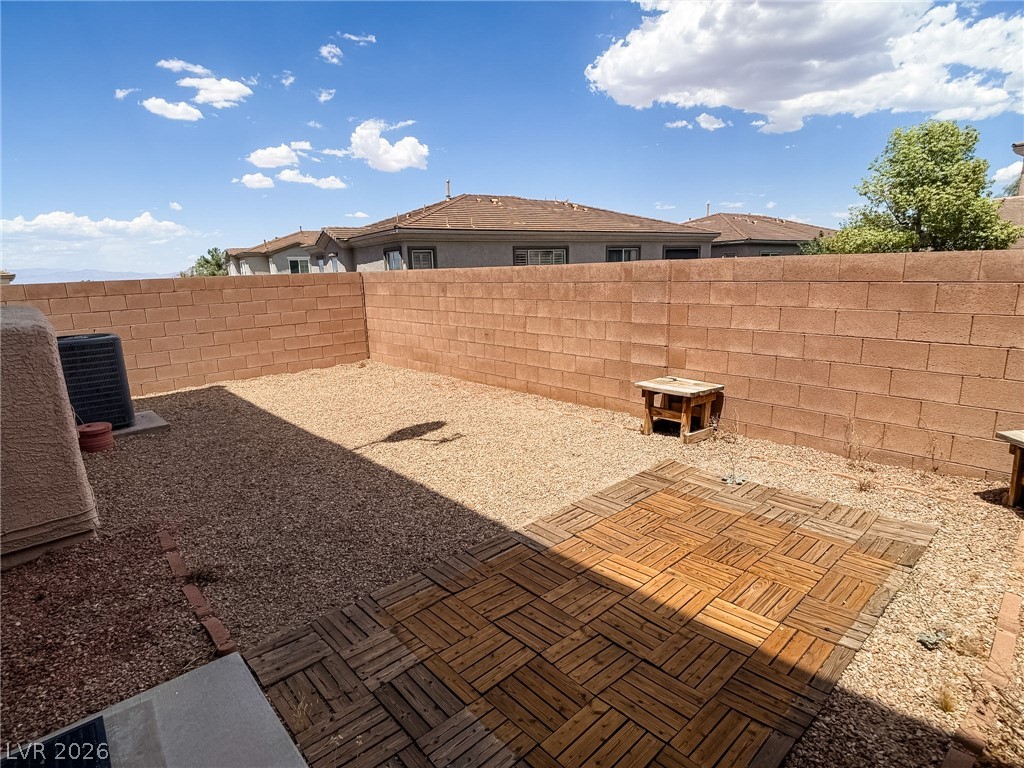 228 Positive Point Street Henderson, NV 89012 - Photo 24 of 27 A private yard features a wood patio and gravel landscaping, framed by sturdy block walls.