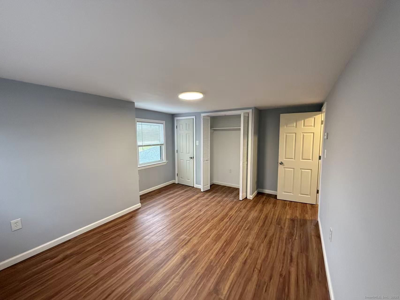 151 Bitgood Road Griswold, CT 06351 - Photo 17 of 20 a view of an empty room with window and wooden floor