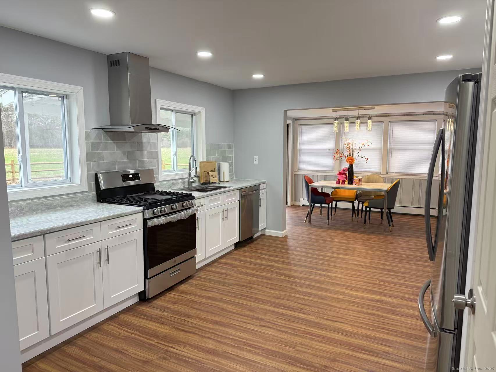 151 Bitgood Road Griswold, CT 06351 - Photo 7 of 20 a kitchen with stainless steel appliances granite countertop wooden floors a stove and a window