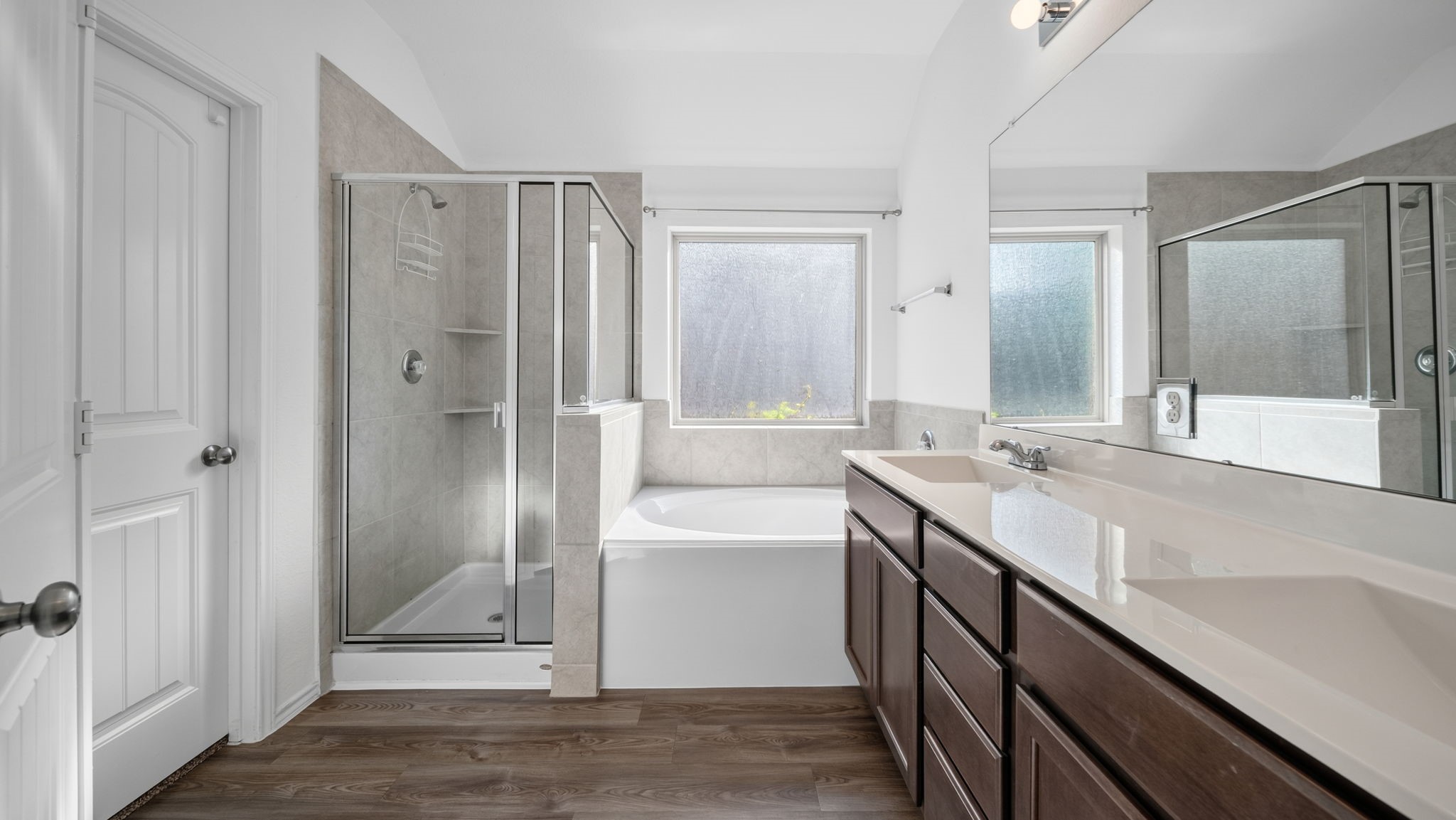 12348 Delta Timber Road Conroe, TX 77304 - Photo 11 of 22 Enjoy a luxurious primary bath featuring an oversized walk-in shower, a relaxing soaking tub, dual-sink vanity with ample storage, and a large window that fills the space with natural light.