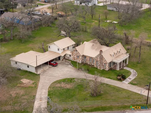 an aerial view of a house with a yard and lake view