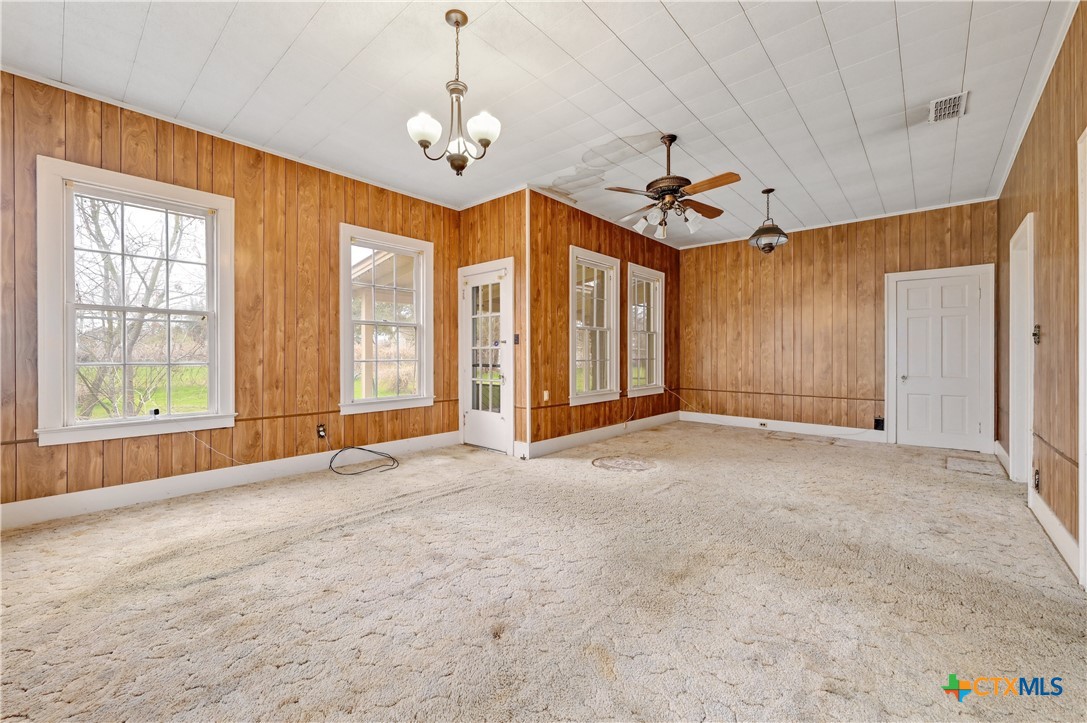 222 Myrtle Avenue Luling, TX 78648 - Photo 23 of 44 a view of an empty room with chandelier fan and windows