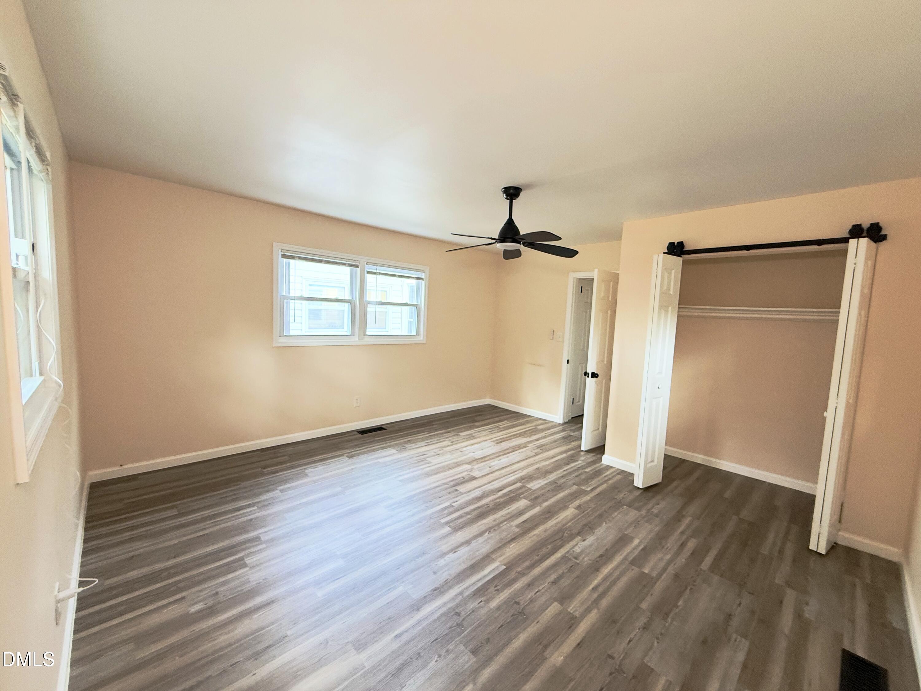 417 North Street Graham, NC 27253 - Photo 14 of 18 an empty room with wooden floor a ceiling fan and windows