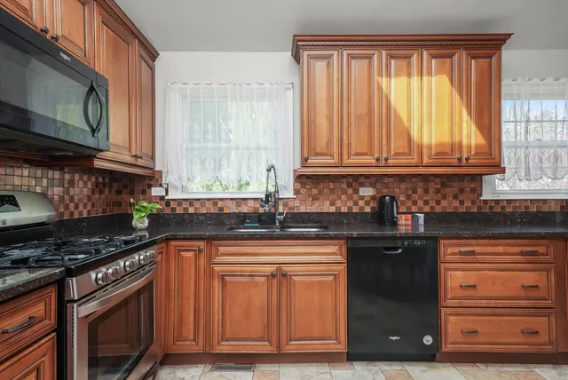 a kitchen with granite countertop wooden cabinets and a stove top oven