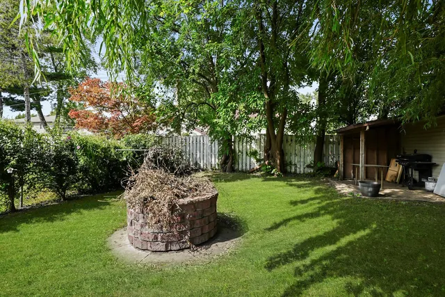 a view of a backyard with table and chairs and a tree
