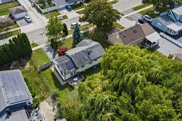 an aerial view of residential house with outdoor space and trees all around