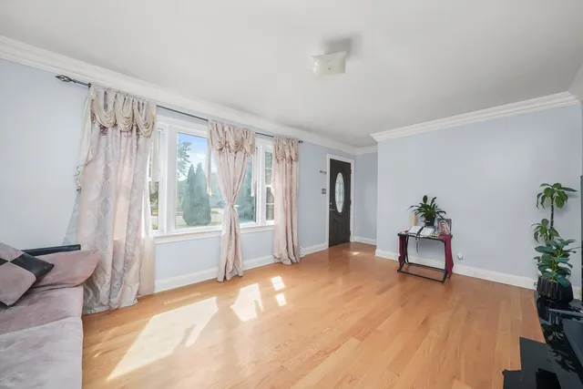 a view of a livingroom with a window and wooden floor