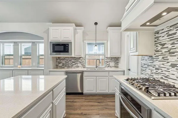 a kitchen with stainless steel appliances kitchen island granite countertop a stove and a sink