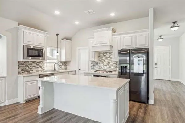 a view of kitchen with wooden floor and electronic appliances