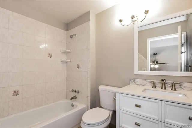 a bathroom with a granite countertop sink a toilet and a bathtub