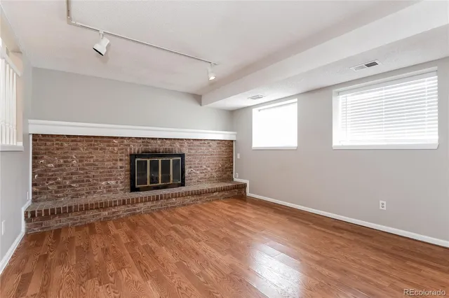 a view of an empty room with a fireplace and a window