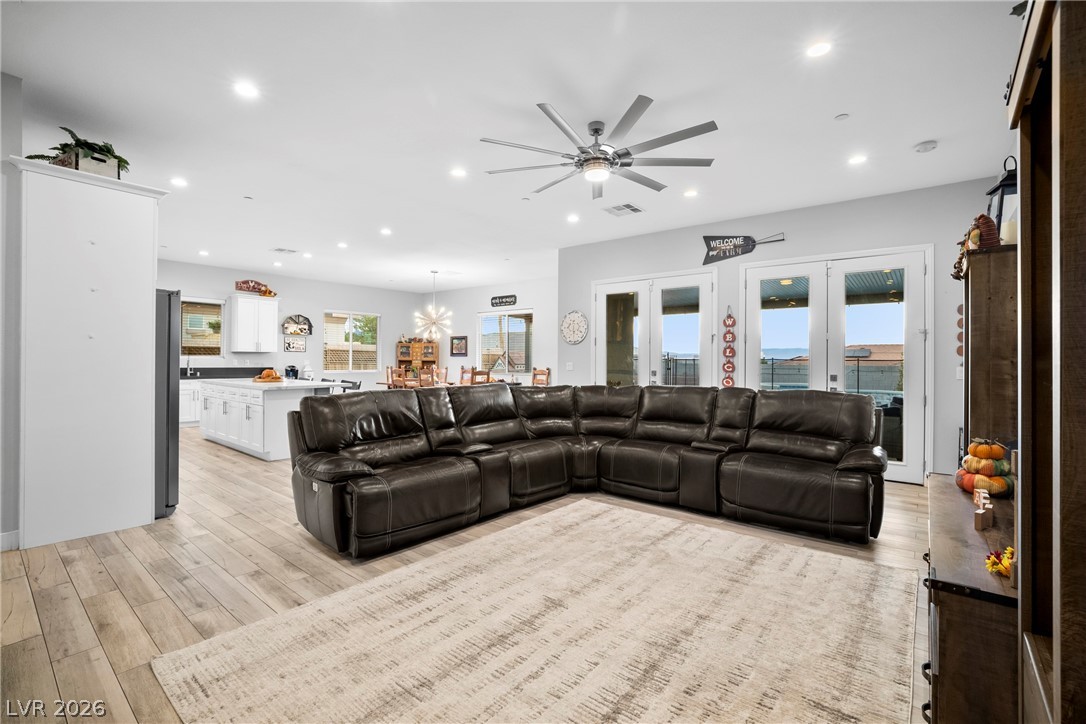 432 North Racetrack Road Henderson, NV 89015 - Photo 5 of 45 Living room featuring ceiling fan, light wood-style floors, and hanging lights